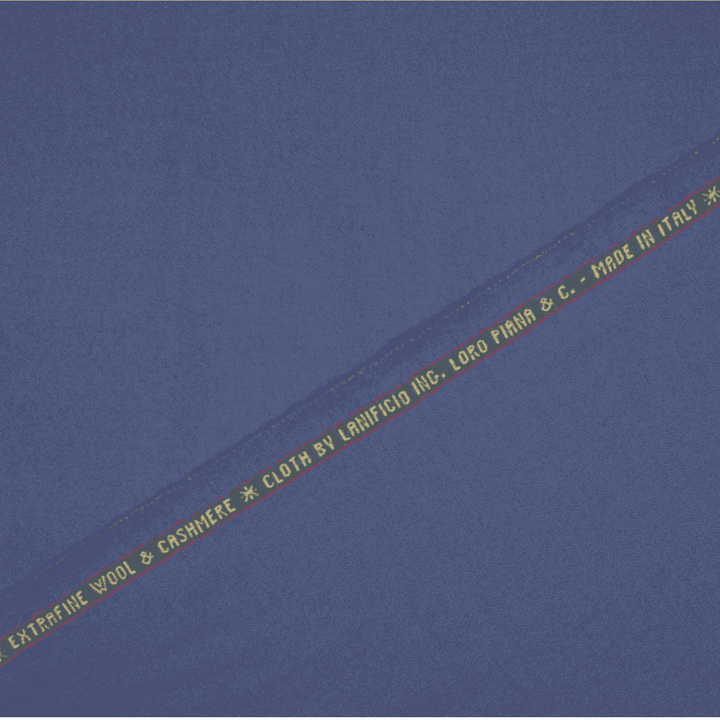 A swatch of periwinkle blue Loro Piana wool & cashmere superfine suitiing fabric with the brand name and content information printed on the fabric.