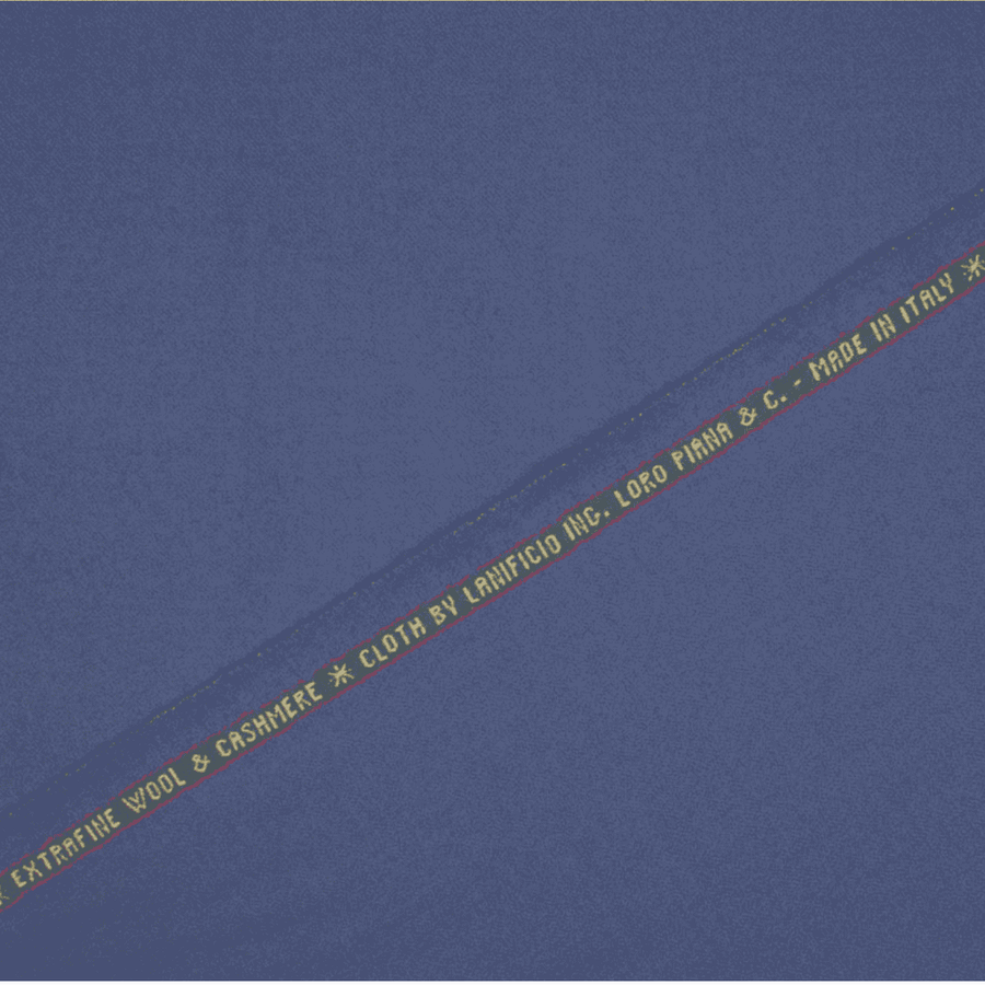 A swatch of periwinkle blue Loro Piana wool & cashmere superfine suitiing fabric with the brand name and content information printed on the fabric.