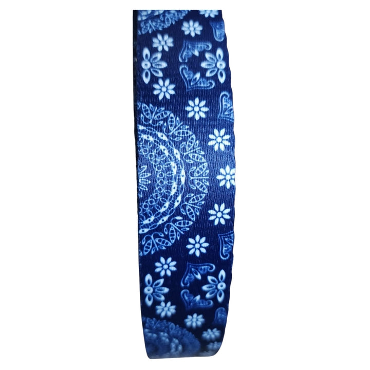 Blue ribbon with white floral and paisley pattern on a white background